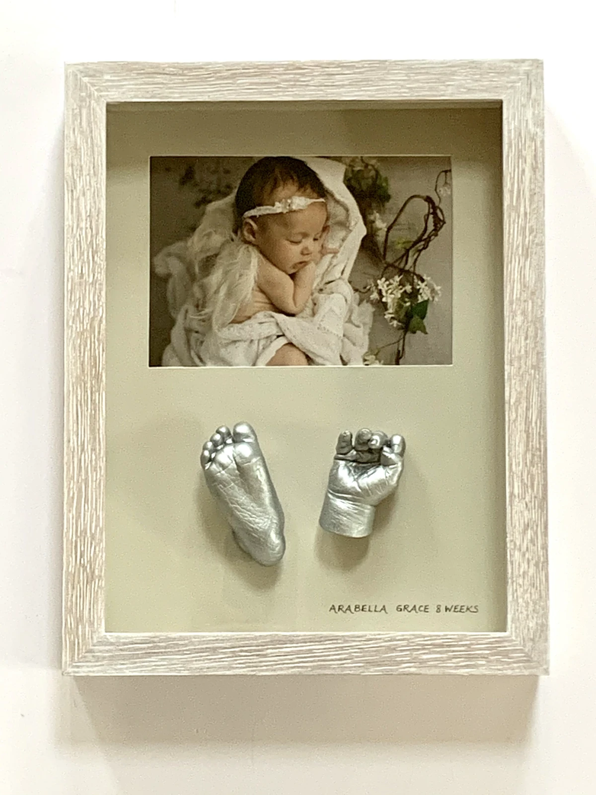 Hand and foot casts in a decorative frame